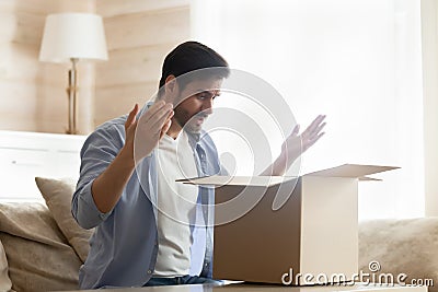 Frustrated male customer unpack box disappointed with order Stock Photo