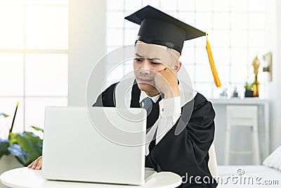 Frustrated male graduation trying to learn online at home Stock Photo