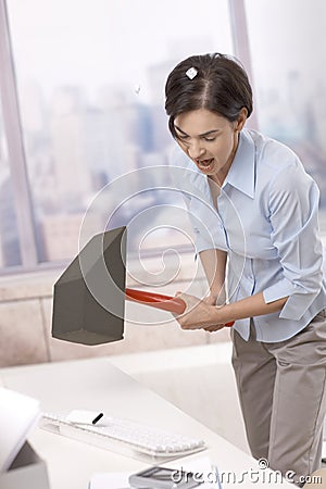 Frustrated office worker smashing keyboard Stock Photo