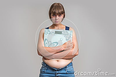 Frustrated overweight woman with scales Stock Photo