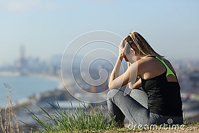 Frustrated runner sitting outdoors complaining Stock Photo