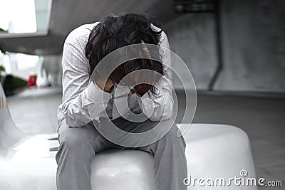 Frustrated stressed young Asian business man with hands covering face and feeling disappionted or exhausted with job. Stock Photo