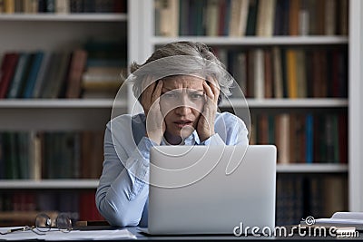 Frustrated tired older business lady shocked with bad news Stock Photo