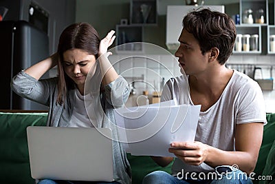 Frustrated wife disagreeing with angry husband blaming of oversp Stock Photo