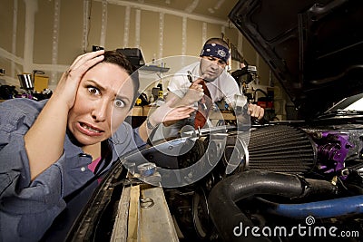 Frustrated woman with incompetent mechanic in back Stock Photo