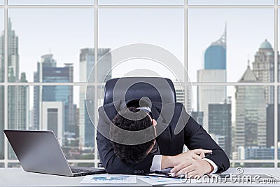 Frustrated worker sleeping in the office Stock Photo