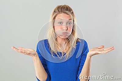 Frustrated young blond woman puffing her cheeks out Stock Photo