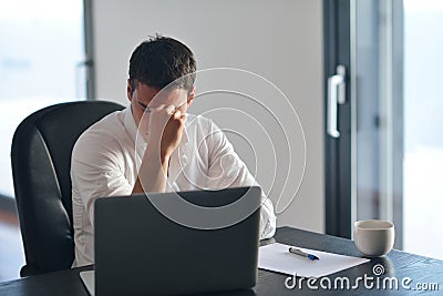 Frustrated young business man working on laptop computer at home Stock Photo