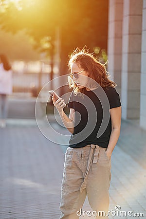 Frustrated young woman with gaping mouth looking at her phone. Stock Photo