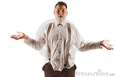 Frustration, resentment. Overweight boy in white shirt and suspenders isolated over white studio background. Concept of Stock Photo