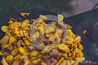 Fry potatoes on open fire in the open air Stock Photo