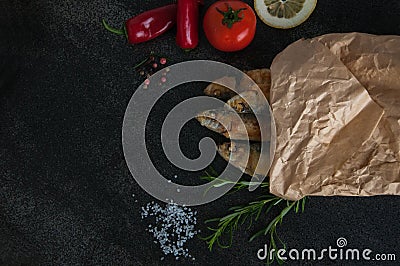 Fry sardines. roast, broi, grill fish packaged in paper with vegetables and spices around Stock Photo