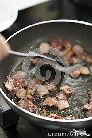 Frying bacon in oily pan Stock Photo