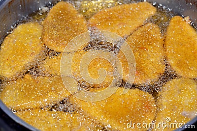 Frying classic breaded chicken pane cuisine in deep oil background, selective focus of chicken pane, tenders, fillet or goujons Stock Photo