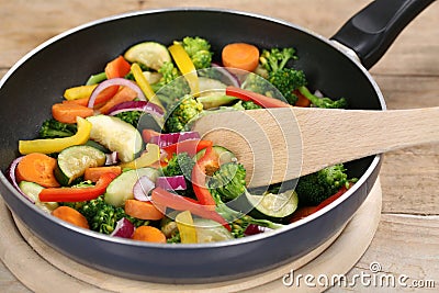 Frying food vegetables in cooking pan with spatula Stock Photo