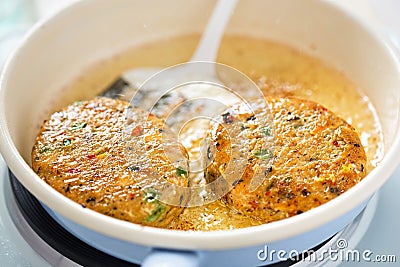 Frying in oil on pan salmon fishcakes Stock Photo
