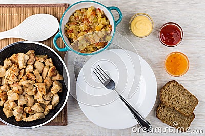 Frying pan with fried chicken meat, ratatouille, bread, sauces, Stock Photo