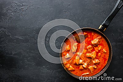 Frying pan with stewed meat on a black background and space for text Stock Photo