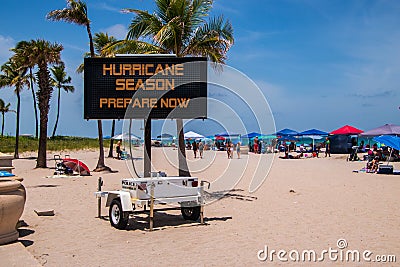 This is a sign on a beach on a hot summer day warning that it is hurricane season and that Editorial Stock Photo