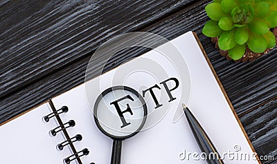 FTP File Transfer Protocol text written in a notebook with a magnifying glass, pen and cactus Stock Photo