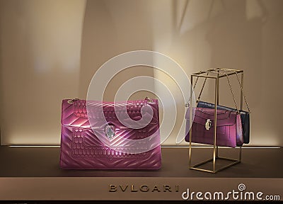 Fuchsia pink-purple Bulgari small women leather bags in the window Editorial Stock Photo