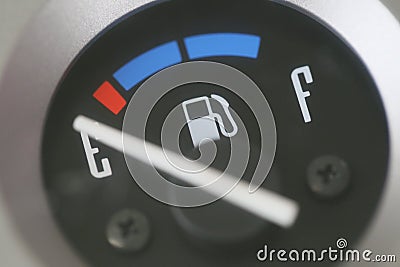Fuel gauge with warning indicating low fuel tank. Stock Photo