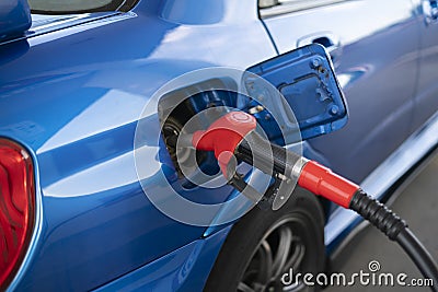 a fuel pump inserted in the sport car on the fuel station, pour gasoline oil in the vehicle Stock Photo