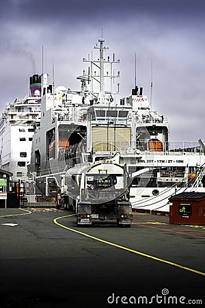 Fuel trucks fuelling cruise ships and war ships at the docks of a Canadian harbour. Editorial Stock Photo