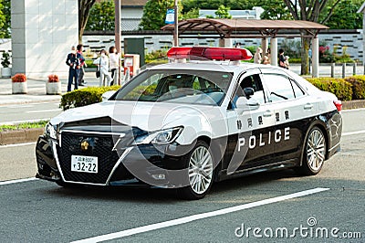 Tokyo 2020 Olympic Torch Relay. Car parade with police car ensuring safety in Fuji City, Japan. Close-up Editorial Stock Photo