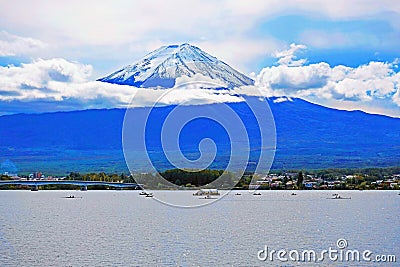 Fujiyama mountain before the lake with trees, houses, buildings, bridge, and ships . Stock Photo