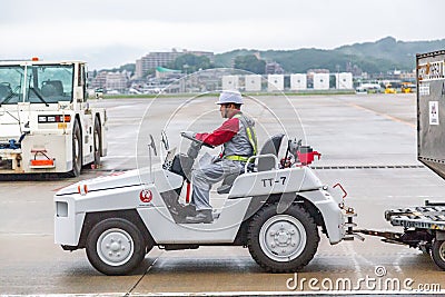 Japanese airport baggage handler, or known as ramper, driving a baggage truck Editorial Stock Photo