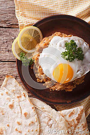 Ful medames with a fried egg and bread close-up. vertical top vi Stock Photo