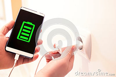 Full battery charged by a charger. phone charging from a wall outlet Stock Photo