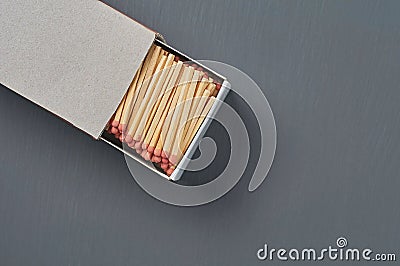 Full big cardboard matchbox of many matchsticks with red sulfur on dark concrete table on kitchen Stock Photo