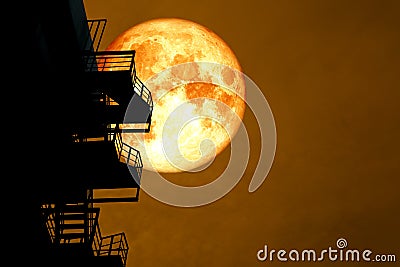 full blood moon over silhouette stair case and colorful sky Stock Photo