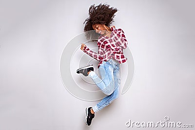 Full body cheerful young african woman jumping in air over white background Stock Photo