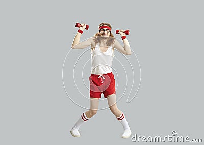 Funny tired skinny man doing exercise with gym dumbbells isolated on gray background Stock Photo