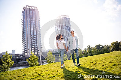 Full body length photo of beautiful couple students soulmates holding hands together looking green backyard city Stock Photo