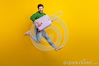 Full body length photo of crazy screaming young man guitarist holding luggage suitcase jumper singing isolated on yellow Stock Photo