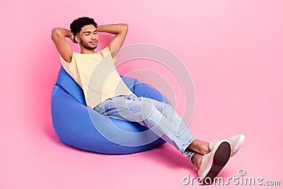 Full body length photo of dreaming sleeping young guy take nap hands head lying beanbag comfortable place isolated on Stock Photo
