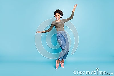 Full body photo of cheerful funny mulatto girl have free time listen music on her headset dance sing enjoy wear stylish Stock Photo