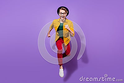 Full body photo of cheerful happy young man jump up run hurry sale good mood isolated on violet color background Stock Photo