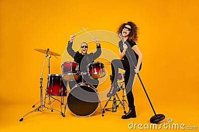 Full body photo of cool rock group handsome guy play drum instruments crazy girl sing old fashion mic concert popular Stock Photo