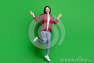 Full body photo of crazy brunette hairdo young lady jump wear red shirt jeans isolated on green color background Stock Photo