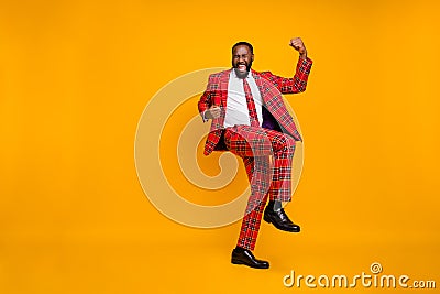 Full body photo of crazy ecstatic dark skin guy raise fists celebrate successful achieve good mood wear plaid red Stock Photo