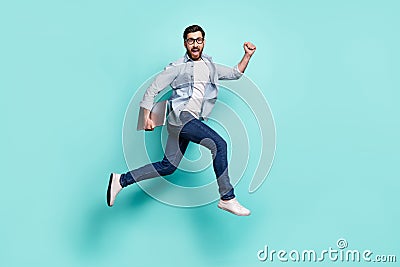 Full body photo of delighted overjoyed man hurry running jump isolated on teal color background Stock Photo