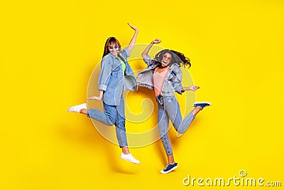 Full body photo of excited active girls dark skin raise hands have good mood isolated on yellow color background Stock Photo