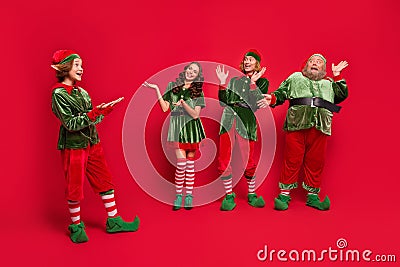 Full body photo of happy amazed santa helper wear hat xmas atmosphere raise hands isolated on red color background Stock Photo