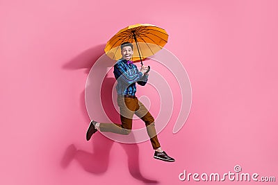 Full body photo of hurry up running gentlemen enjoying retro glamour outfit holding bright umbrella isolated on pink Stock Photo