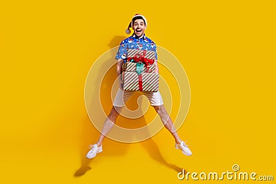 Full body photo of impressed overjoyed person jumping arms hold pile stack festive giftbox isolated on yellow color Stock Photo